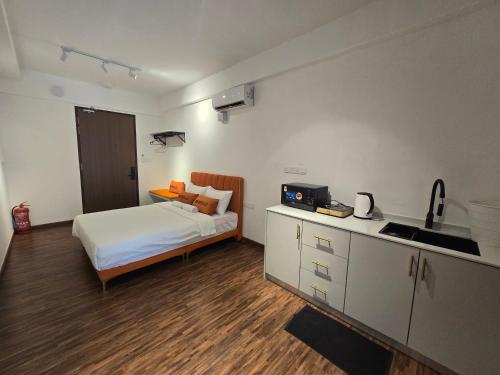 a bedroom with a bed and a kitchen with a sink at K Avenue Sunset View Condomonium - Kota Kinabalu Airport in Kota Kinabalu