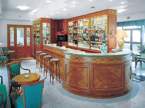 eine Bar in einem Restaurant mit vielen Tischen und Stühlen in der Unterkunft Hotel La Castellana in Belvedere Marittimo