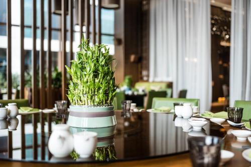 a dining room with a table with a plant on it at Baku Marriott Hotel Boulevard in Baku