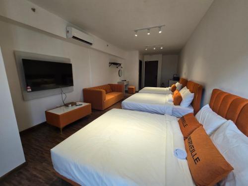 a hotel room with two beds and a flat screen tv at K Avenue Sunset View Condomonium - Kota Kinabalu Airport in Kota Kinabalu