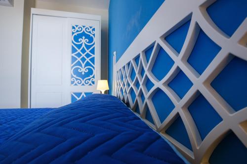 a blue bedroom with a bed and a window at Holiday Lodge al Porto in Mattinata