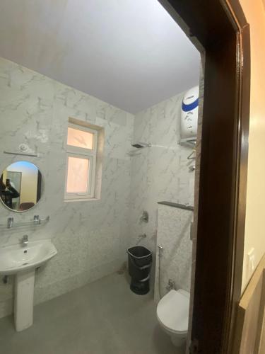 a bathroom with a sink and a toilet and a window at Harmony Heights in Shimla