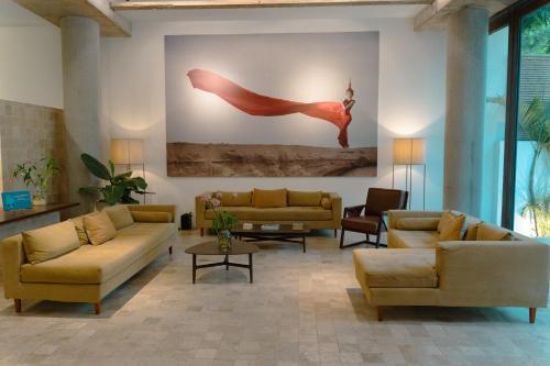 a living room with couches and a painting on the wall at Penh House Hotel in Phnom Penh