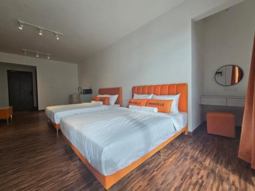 two beds in a room with wood floors at K Avenue Sunset View Condomonium - Kota Kinabalu Airport in Kota Kinabalu