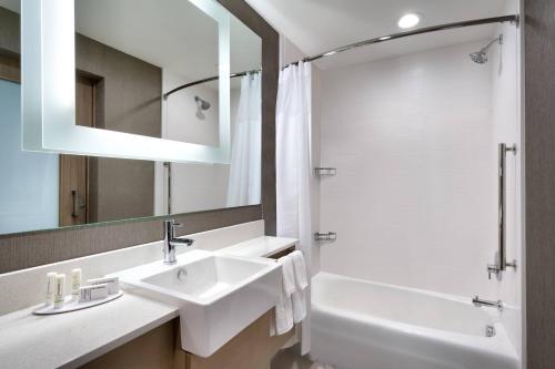 a white bathroom with a sink and a shower at SpringHill Suites By Marriott Salt Lake City West Valley in West Valley City