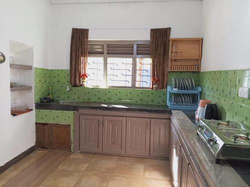 cocina con paredes verdes y encimera en Piya House, en Weligama