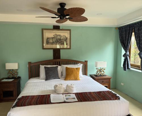 a bedroom with a large bed with a ceiling fan at On The Mekong Resort in Luang Prabang