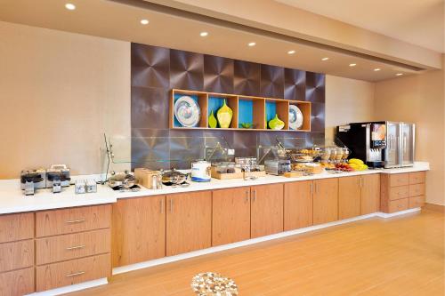 a large kitchen with wooden cabinets and a counter top at Springhill Suites by Marriott Anaheim Maingate in Anaheim