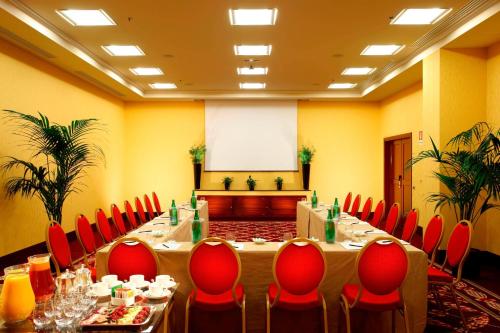 a meeting room with a long table and red chairs at Rome Marriott Park Hotel in Rome