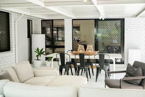 a living room with white furniture and a table and chairs at Central 3 Bdr House - Walk to town & pub in Bangalow