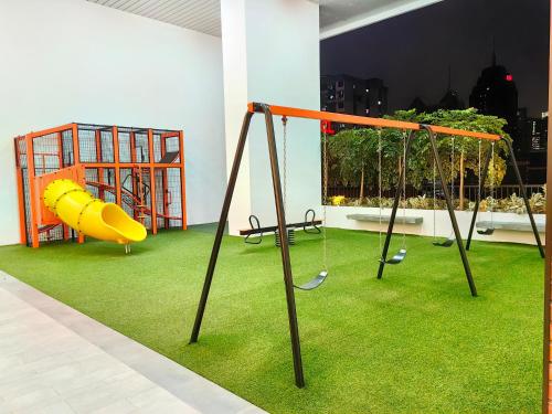 a play area with swings and grass at Chambers KLCC Serviced Suites One in Kuala Lumpur