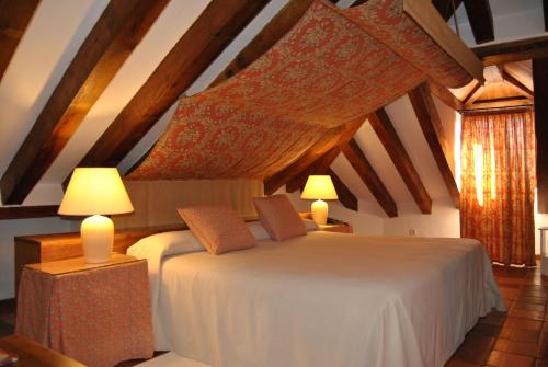 a hotel room with a bed and two lamps at El Hotel De La Villa in Pedraza-Segovia