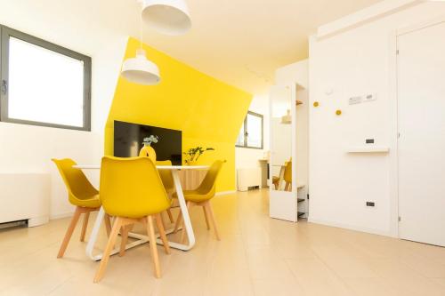 une salle à manger avec une table et des chaises jaunes dans l'établissement Sunny retreat near metro, 12 min to Duomo, à Milan
