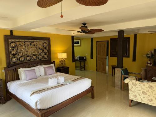 a bedroom with a large bed and a living room at On The Mekong Resort in Luang Prabang