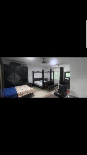 a bedroom with a bed and a couch and a chair at DD Empire Homestay in Jeram