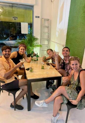 a group of people sitting around a wooden table at PROpaganda Hostel in Koh Phangan