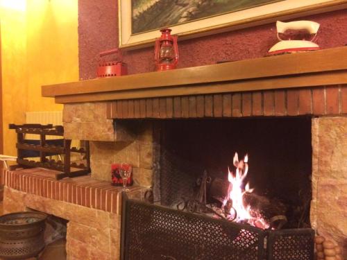 a brick fireplace with a fire in it at Villa Montemma in Montesarchio