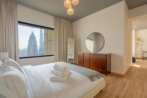a bedroom with a white bed with a large window at Stunning Burj Khalifa & Downtown Views - Elegant 1BR in The Iconic Index Tower in Dubai