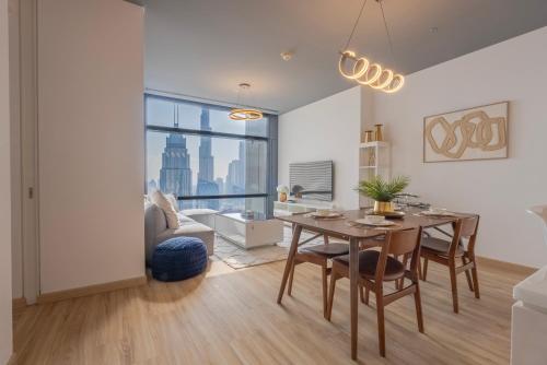 a living room with a table and chairs and a couch at Stunning Burj Khalifa & Downtown Views - Elegant 1BR in The Iconic Index Tower in Dubai