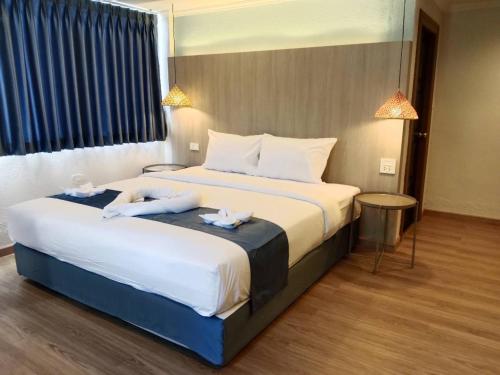 a hotel room with a large bed with towels on it at Eastique Hotel Koh Chang in Trat