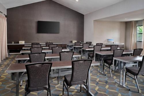 a conference room with tables and chairs and a flat screen tv at Residence Inn Costa Mesa Newport Beach in Costa Mesa
