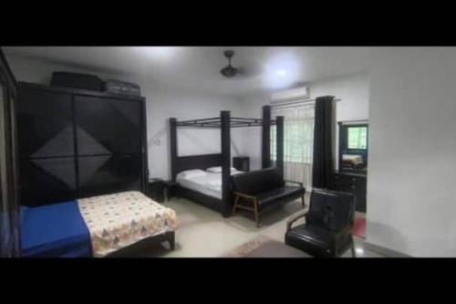 a bedroom with two bunk beds and a chair at DD Empire Homestay in Jeram