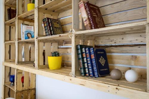 a wooden book shelf with books on it at Cassari UpArtments in Palermo
