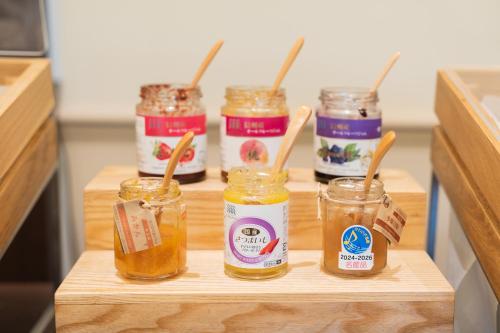 a group of four jars of honey on a cutting board at Hotel ARU KSP in Kawasaki