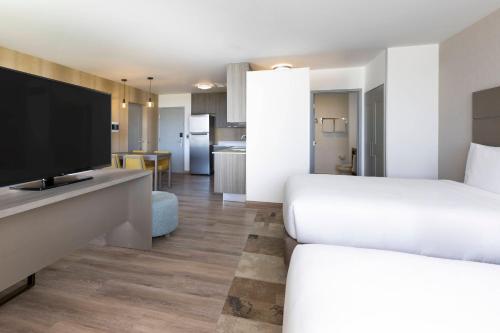 a hotel room with two beds and a flat screen tv at Residence Inn by Marriott Cancun Hotel Zone in Cancún