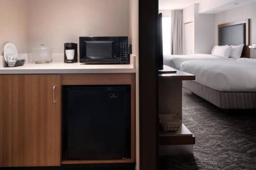 a hotel room with a television and a bed at SpringHill Suites by Marriott Syracuse Carrier Circle in East Syracuse