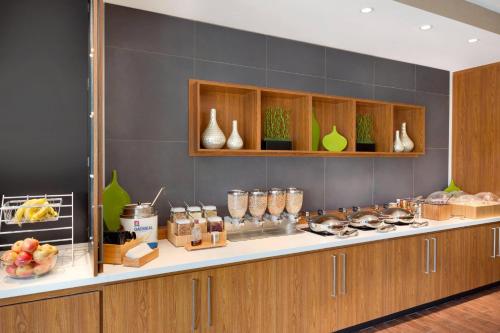 a kitchen with wooden cabinets and a counter with food at SpringHill Suites by Marriott Tuscaloosa in Tuscaloosa