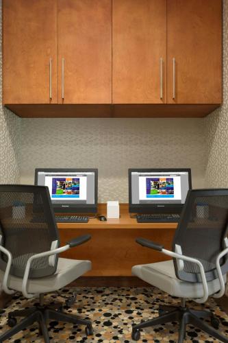 a desk with two computer monitors and two chairs at SpringHill Suites by Marriott Tuscaloosa in Tuscaloosa