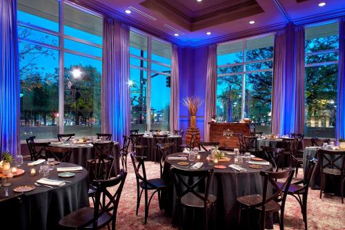 a ballroom with tables and chairs in a room with windows at Raleigh Marriott City Center in Raleigh