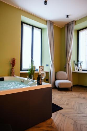 a bathroom with a tub in a room with windows at Maison Giulietta e Spa con parcheggio privato in Como