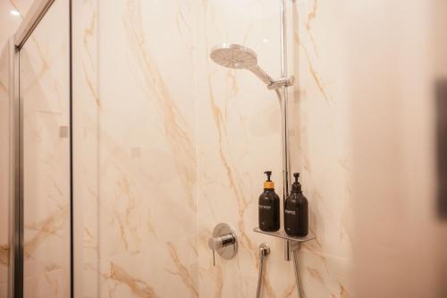 a shower with two bottles on the wall at Maison Giulietta e Spa con parcheggio privato in Como