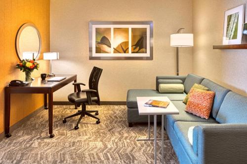 a living room with a couch and a desk in a hotel room at SpringHill Suites by Marriott Salt Lake City Downtown in Salt Lake City