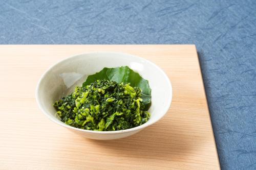 a white bowl of broccoli on a wooden table at Vessel Inn Hiroshima Station in Hiroshima
