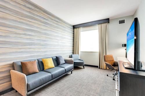 a living room with a couch and a flat screen tv at Residence Inn by Marriott Corpus Christi Downtown in Corpus Christi