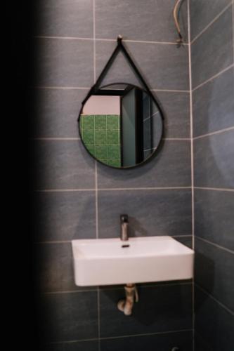 a bathroom with a sink and a mirror on a wall at Mercury Hotel & Apartment in Vung Tau