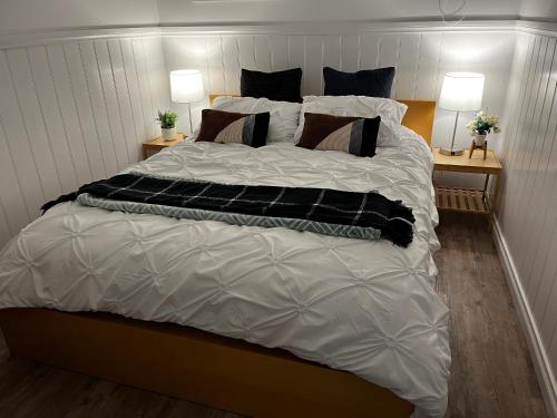 a large bed with black and white sheets and pillows at Sea Lake Holiday Cabin in Sea Lake