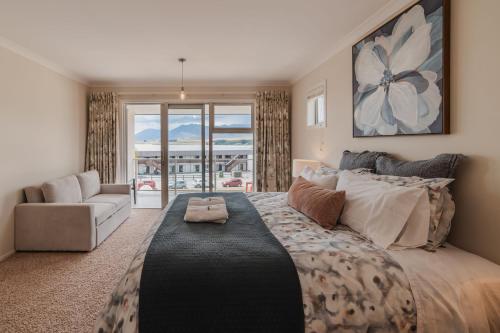 a bedroom with a large bed and a couch at Starlight Lakeview Vista - 5BR Hideaway & Hot Tub in Lake Tekapo