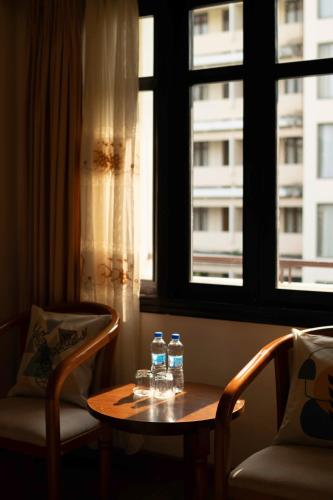 two bottles of water sitting on a table in front of a window at Mercury Hotel & Apartment in Vung Tau