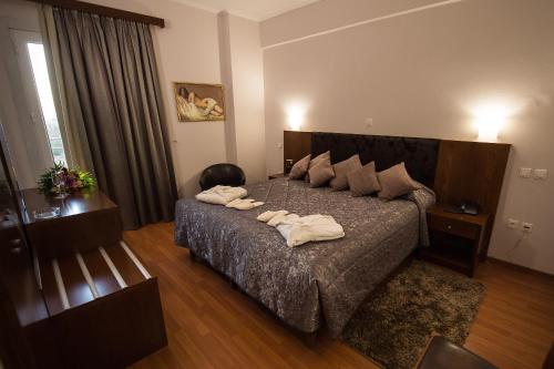 Hotel Olympos في بيغروس: غرفة نوم عليها سرير وفوط
