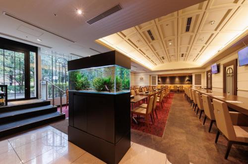 a dining room with tables and chairs in a restaurant at Hotel ARU KSP in Kawasaki