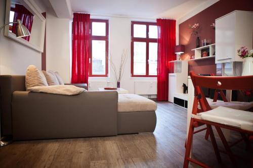 a living room with a couch and red curtains at Ferienwohnungen und Ferienhäuser Gohr in Stralsund