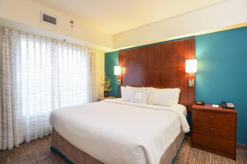 a bedroom with a large bed and a blue wall at Residence Inn Cincinnati North West Chester in West Chester