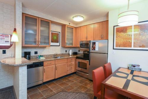 a kitchen with wooden cabinets and stainless steel appliances at Residence Inn Cincinnati North West Chester in West Chester