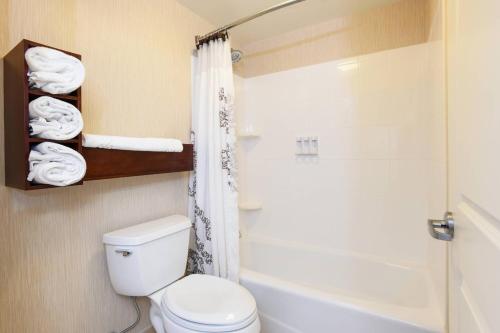 a bathroom with a toilet and a shower with towels at Residence Inn Cincinnati North West Chester in West Chester