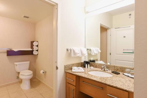 a bathroom with a sink and a toilet and a mirror at Residence Inn Cincinnati North West Chester in West Chester