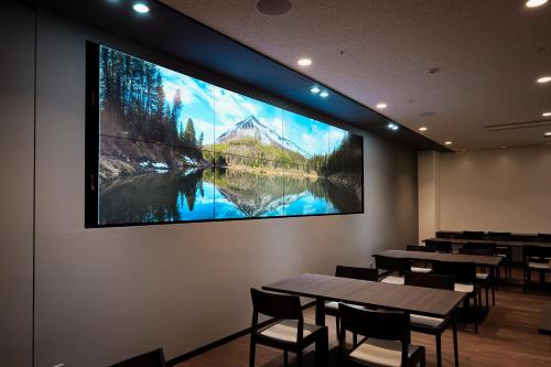 a large projection screen on the wall of a restaurant at Hotel ARU KSP in Kawasaki